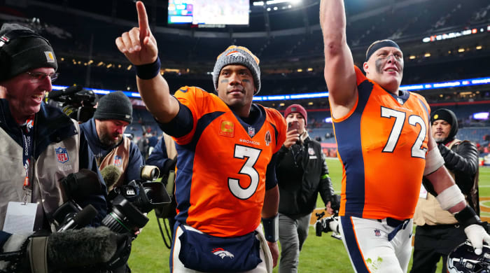 Russell Wilson points one finger in the air while OT Garett Bolles does the same walking next to him